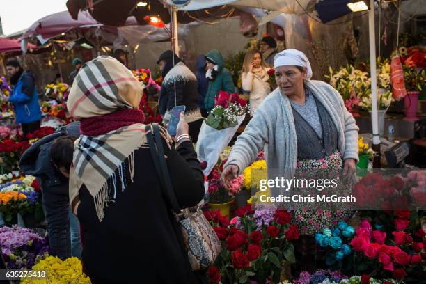 Stall owner sells a bunch of roses to a customer helps a customer celebrating Valentine's Day at a flower stall in Taksim square on February 14, 2017...