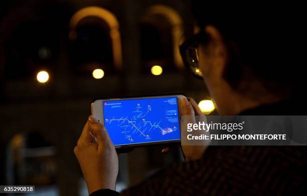 Italian digital artist and marketer Maria Beatrice Alonzi looks at the map on her smart phone showing the police stations closest to each stop for...