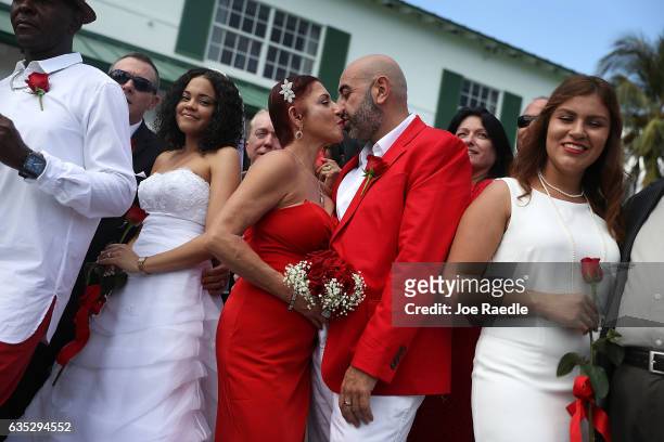 Carmen Lombardo and Armando Merola kiss as they participate in a group Valentine's day wedding at the National Croquet Center on February 14, 2017 in...