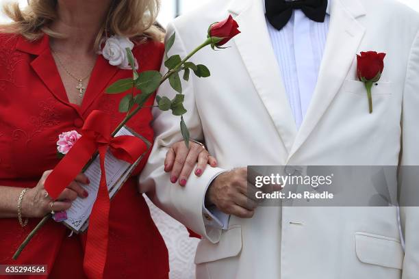 Couple stands together as they participate in a group Valentine's day wedding ceremony at the National Croquet Center on February 14, 2017 in West...