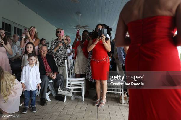 Friends and relatives watch as loved ones arrive to participate in a group Valentine's day wedding ceremony at the National Croquet Center on...