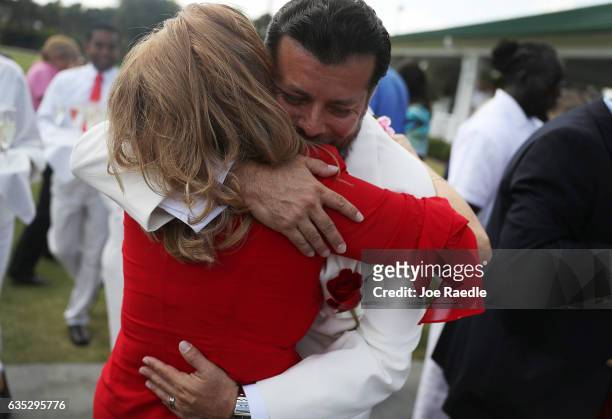 Susan Briceno hugs her husband, Alonso J. Briceno, after participating in a group Valentine's day wedding ceremony at the National Croquet Center on...