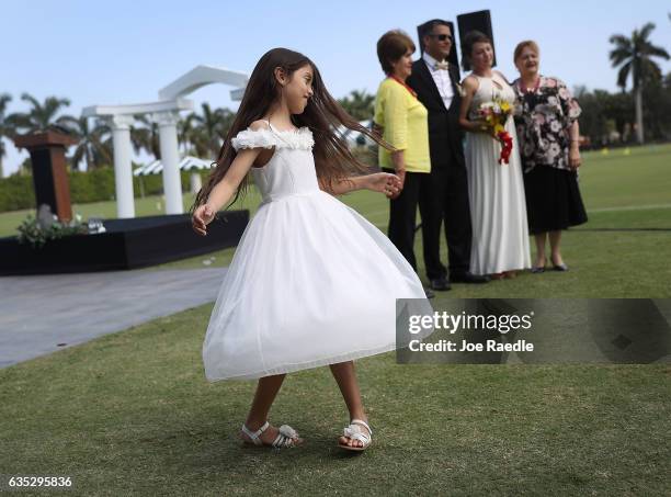 Mariana Guzman spins around after her relatives participated in a group Valentine's day wedding ceremony at the National Croquet Center on February...