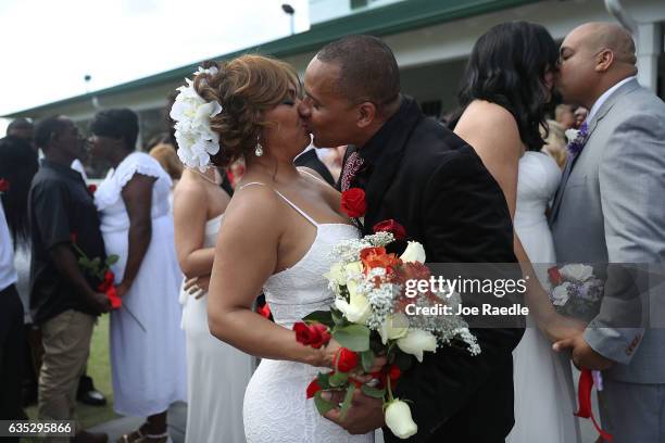 Wendy Ramirez and Anthony Moore kiss as they are wed during a group Valentine's day wedding at the National Croquet Center on February 14, 2017 in...
