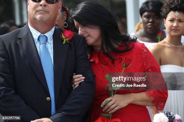 Sean Logsdon and Tina Logsdon stand together as they are married in a group Valentine's day wedding ceremony at the National Croquet Center on...