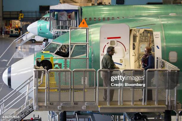 Employees speak on a platform next to a Boeing Co. 737 MAX 9 jetliner at the company's manufacturing facility in Renton, Washington, U.S., on Monday,...