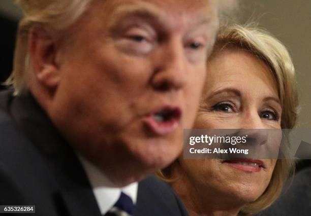 President Donald Trump speaks as Secretary of Education Betsy DeVos listens during a parent-teacher conference at the Roosevelt Room of the White...