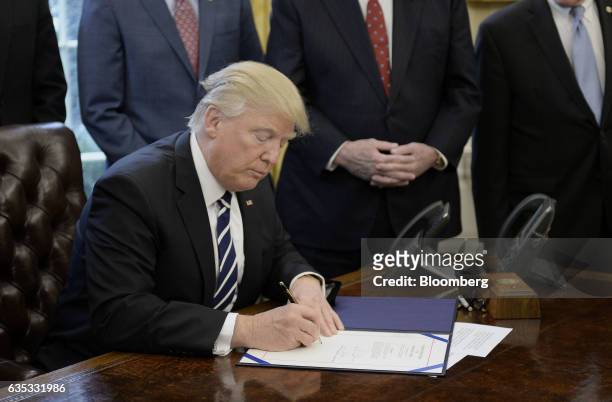 President Donald Trump signs executive orders inside the Oval Office of the White House in Washington, D.C., U.S., on Tuesday, Feb. 14, 2017. Michael...