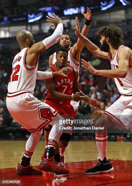 Kyle Lowry of the Toronto Raptors tries to drive between Taj Gibson, Michael Carter-Williams and Robin Lopez of the Chicago Bulls at the United...
