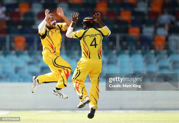 Chad Soper of Papua New Guinea celebrates with Tony Ura of Papua New Guinea after taking the wicket of Aiden Blizzard of ACT during the T20 warm up...