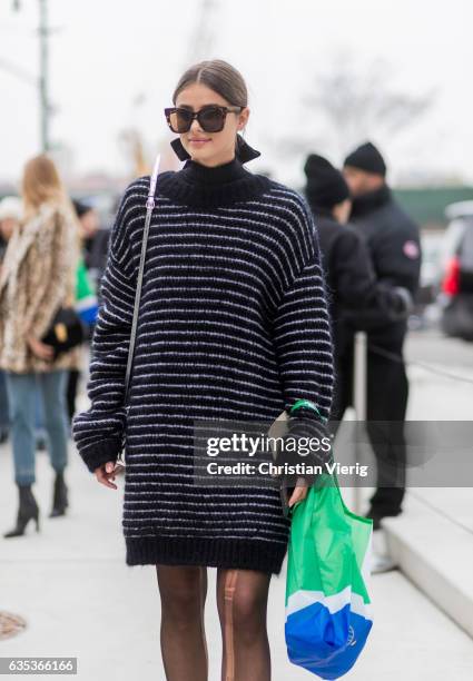 Model Taylor Hill wearing a black white striped oversized knit outside Tory Burch on February 14, 2017 in New York City.