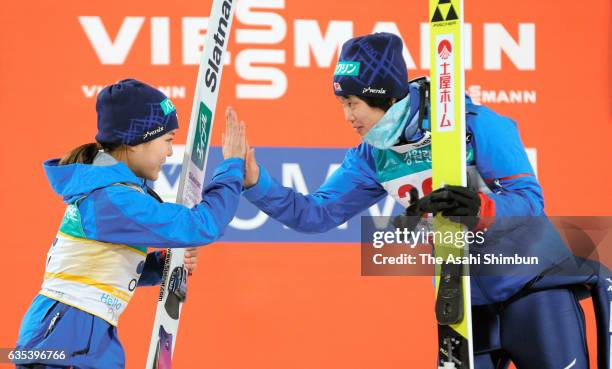 First place Yuki Ito and second place Sara Takanashi of Japan high five on the podium at the award ceremony for the Ladies Normal Hill during day one...