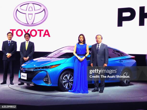 Toyota Motor Co Chairman Takeshi Uchiyamada and actress Satomi Ishihara stand next to the Prius New plug-in hybrid 'PHV' during its unveiling at the...