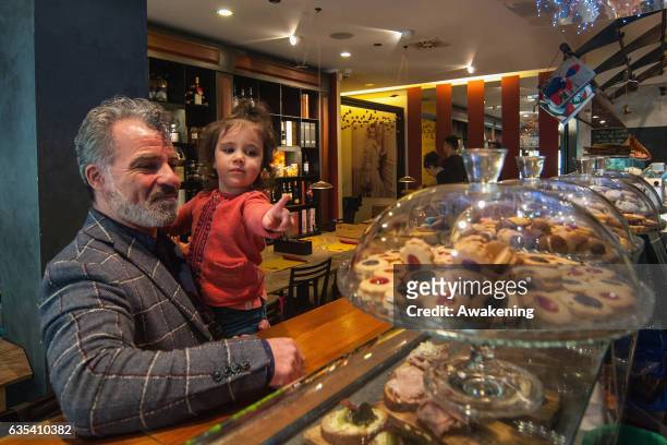 Child looks at some biscuits with her father for lunch in the Antonio Ferrari restaurant on February 15, 2017 in Padova, Italy. The restaurant offers...