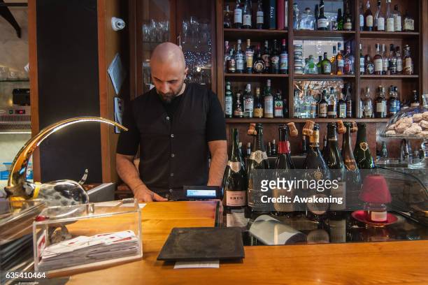 The owner of the Antonio Ferrari restaurant makes a bill on February 15, 2017 in Padova, Italy. The restaurant offers a 5% discount off the total...