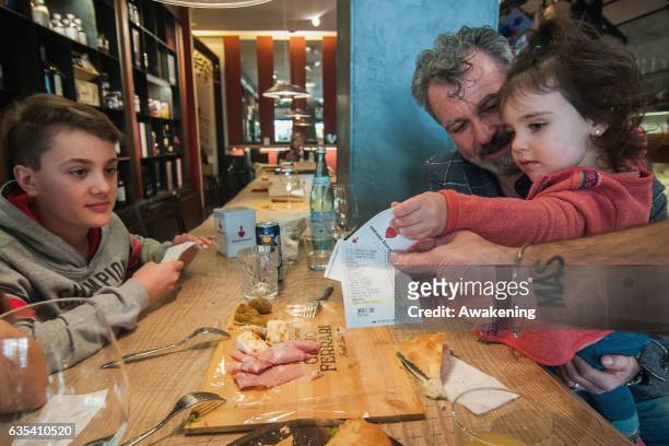 Family receives the bill with the discount of 5% for the good behavior of one child in the Antonio Ferrari restaurant on February 15, 2017 in Padova,...