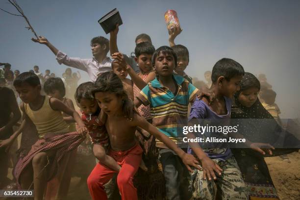 Rohingya refugees run to the crew of the Nautical Aliya as they provide relief supplies at the Balu Khali Rohingya refugee camp on February 15, 2017...