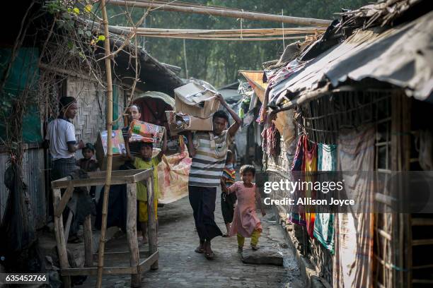 Rohingya refugees carry relief supplies donated by the crew of the Nautical Aliya in the Leda Rohingya refugee camp on February 15, 2017 in...