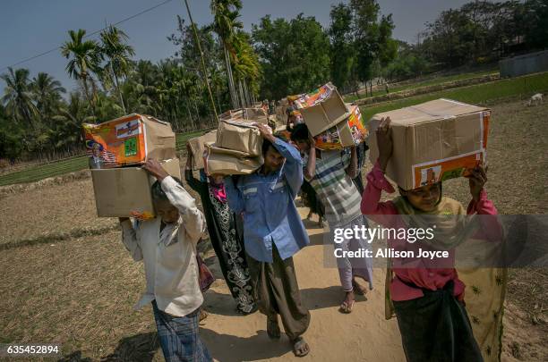 Rohingya refugees carry aid supplies donated by the Nautical Aliya crew at the Balu Khali refugee camp February 15, 2017 in Chittagong, Bangladesh....