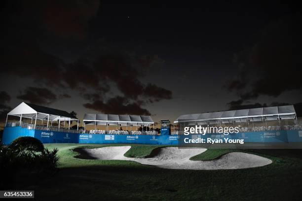 Grounds crews work on the 18th green as it is illuminated by a scoreboard following the first round of the PGA TOUR Champions Allianz Championship at...