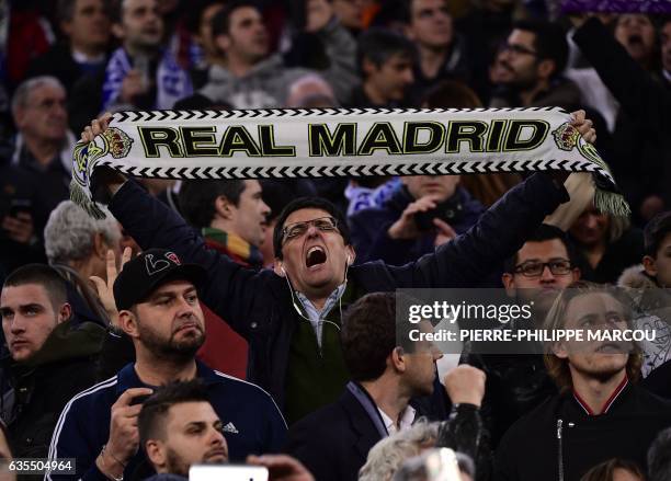 Real Madrid fan holds a scarf during the UEFA Champions League round of 16 first leg football match Real Madrid CF vs SSC Napoli at the Santiago...