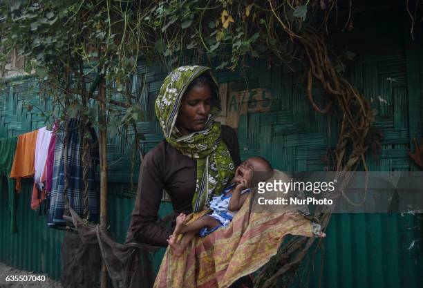 Rohingya women carrying her child in front of the makeshift Leda Rohingya refugee camp on February 15, 2017 in Bangladesh. Thousands of Rohingya...
