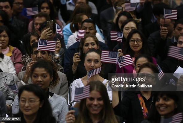 Newly sworn in U.S. Citizens wave American flags during a naturalization ceremony held by U.S. Citizenship and Immigration Services at the Los...