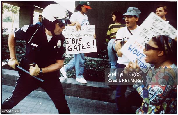 Police officer uses his baton on a protester at the corner of First St. And Broadway on April 29, 1992 in Los Angeles, California.