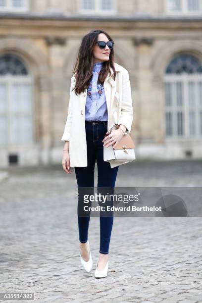 Sarah Benziane, fashion blogger from Les Colonnes de Sarah, wears a Sandro white coat, an Aliexpress blue top with floral print, Primark jeans, a...