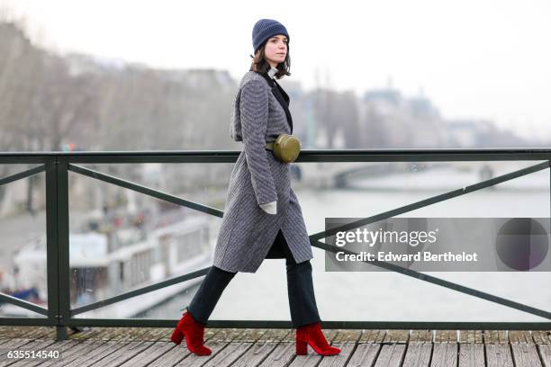 Pauline Darris wears a Cos blue beanie hat, an Eric Bompard pull over, a Zara coat, Levi's 501 vintage jeans, Topshop red boots, and a Darris green...