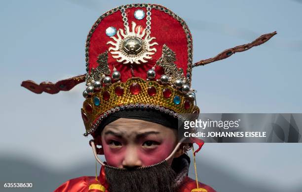 This picture taken on February 11, 2017 shows a boy in traditional clothing waiting to be paraded in a festival through the village of Luofang...