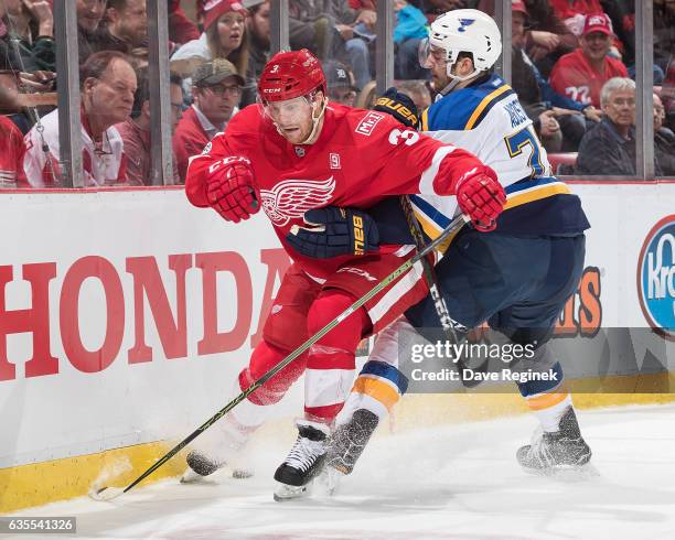 Nick Jensen of the Detroit Red Wings battles along the boards for the puck with Kenny Agostino of the St. Louis Blues during an NHL game at Joe Louis...