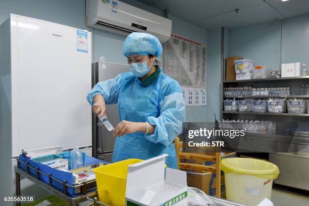 This photo taken on February 12, 2017 shows a nurse preparing medication for an H7N9 bird flu patient in a hospital in Wuhan, central China's Hubei...