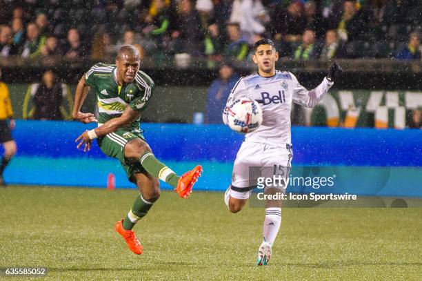 Portland Timbers midfielder Darlington Nagbe takes a shot from outside the box marked by Vancouver Whitecaps midfielder Matias Laba during the first...