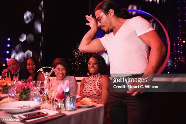 Nusret Gokce or 'Salt Bae' adds salt to the meal of Gymnast Simone Biles of the USA, winner of the Laureus World Sportswoman of the Year Award during...