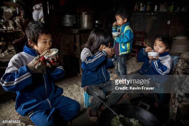 Left behind' children from left to right, Luo Gan Luo Hongni Luo Lie and Luo Hongniu eat together at the family home on December 18, 2016 in Anshun,...
