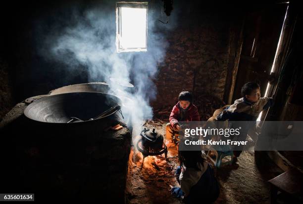 Left behind' children Luo Hongni Luo Lie right, and Luo Hongniu top, sit around a fire at the family home on December 17, 2016 in Anshun, China. Like...
