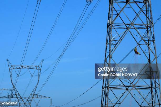 Technician from the RTE installs a sensor, capable of measuring the cooling effect of the mistral on a high-voltage line, on a 400,000 volt power...