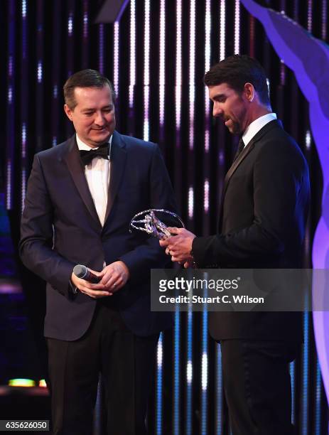 Swimmer Michael Phelps of the USA presents Chairman and owner of the Chicago Cubs Tom Ricketts the Laureus World Team of the Year Award during the...