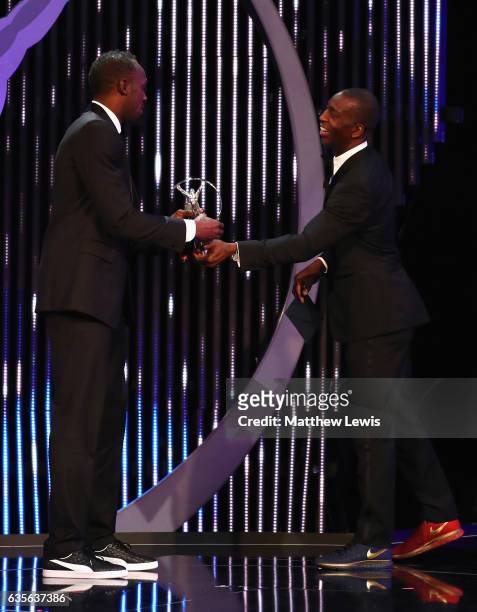 Athlete Usain Bolt of Jamaica accepts his Laureus World Sportsman of the Year award from Laureus Academy member Michael Johnson on stage during the...