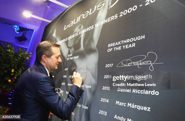 Chairman and owner of the Chicago Cubs Tom Ricketts writes his name on the winners board after receiving the Laureus World Team of the Year award...