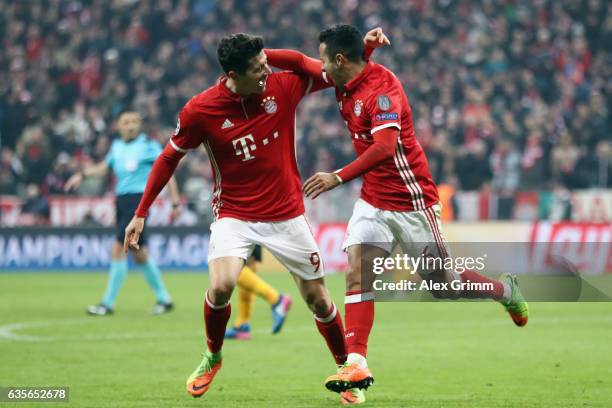 Thiago Alcantara of Muenchen celebrates his team's third goal with team mate Robert Lewandowski during the UEFA Champions League Round of 16 first...