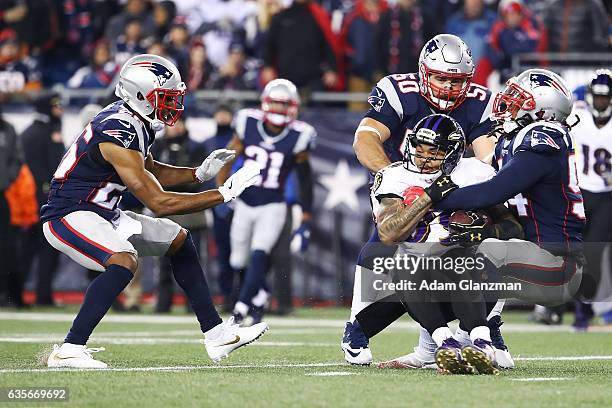 Steve Smith of the Baltimore Ravens is tackled by Rob Ninkovich and Dont'a Hightower of the New England Patriots during a game against the New...