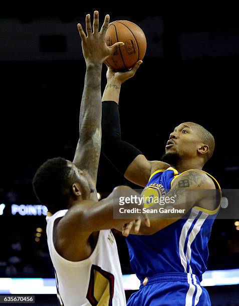 David West of the Golden State Warriors shoot the ball over Terrence Jones of the New Orleans Pelicans during a game at the Smoothie King Center on...