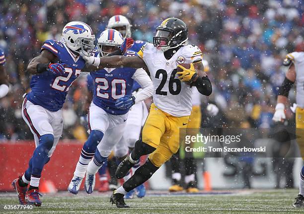 Le'Veon Bell of the Pittsburgh Steelers stiff-arms James Ihedigbo of the Buffalo Bills as he carries the ball during NFL game action at New Era Field...