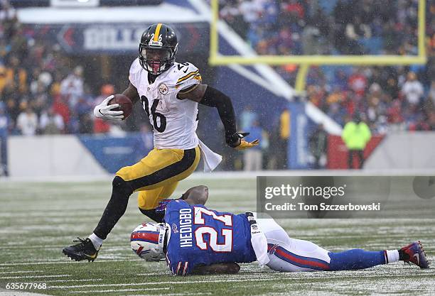 Le'Veon Bell of the Pittsburgh Steelers runs after breaking an attempted tackle by James Ihedigbo of the Buffalo Bills during NFL game action at New...