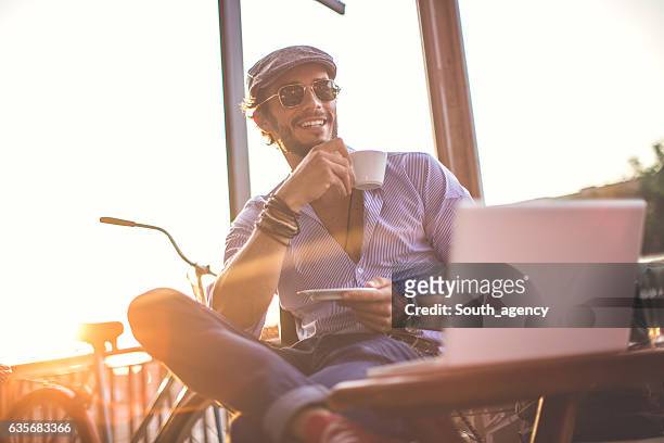 handsome man in cafe - sunlit cafe male stock pictures, royalty-free photos & images