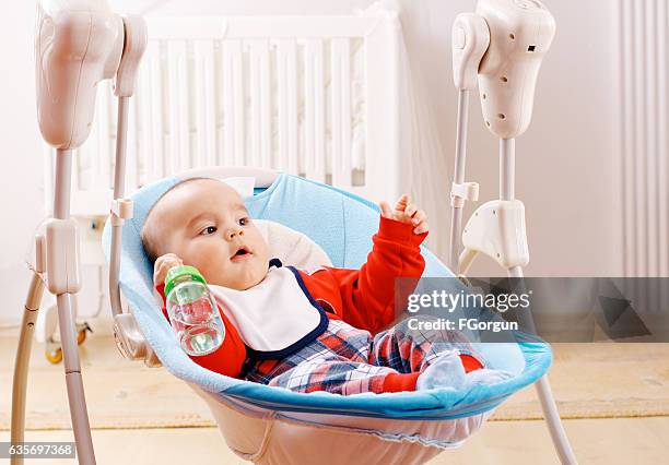 baby boy and water from bottle - baby swing stock pictures, royalty-free photos & images