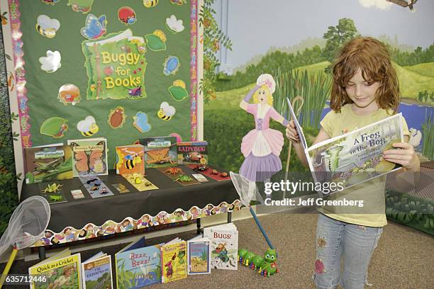 Girl reading a book in the Randolph County Library.