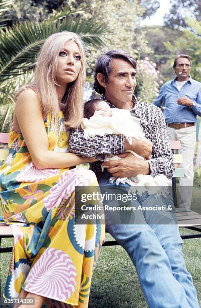 The Italian actor, comician and TV host Walter Chiari holding in the arms his son Simone , who was born in 1970. Seated next to him, the wife Alida...